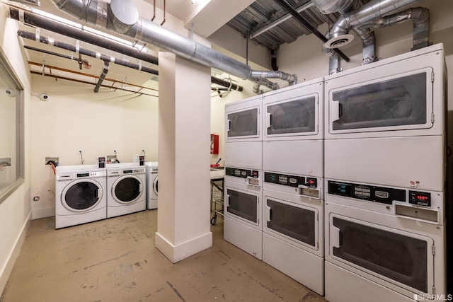 common laundry area with baseboards, stacked washer and dryer, and washer and clothes dryer