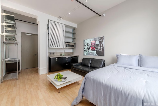 bedroom featuring light wood-type flooring and indoor wet bar