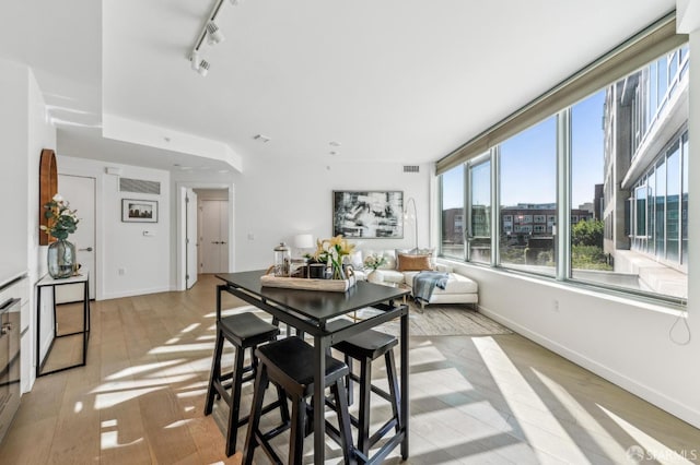 dining room with rail lighting and light hardwood / wood-style flooring