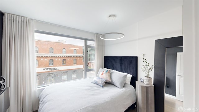 bedroom with access to exterior and wood-type flooring