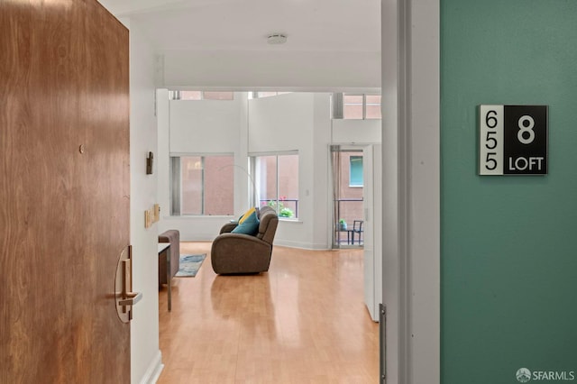 hall with baseboards and wood finished floors