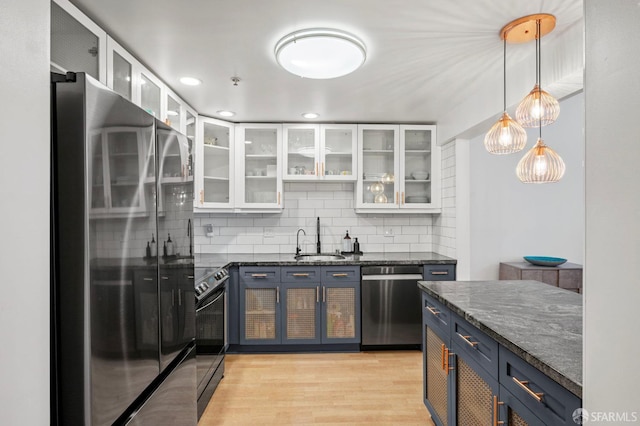 kitchen featuring a sink, blue cabinetry, stainless steel appliances, white cabinetry, and tasteful backsplash