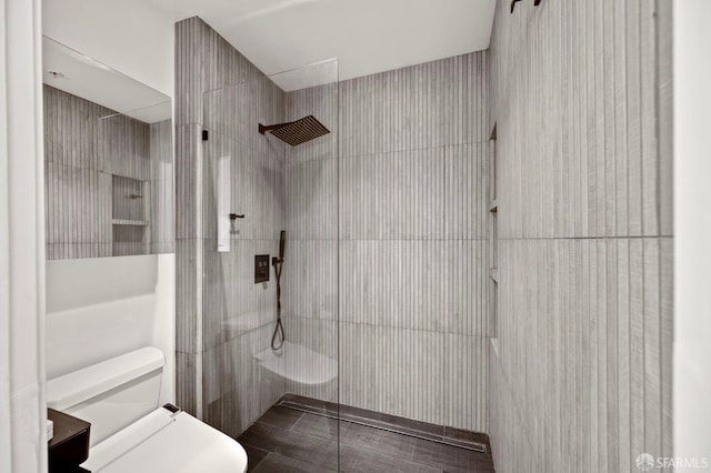 bathroom featuring a walk in shower and toilet