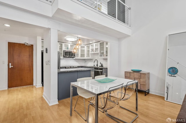 dining space featuring baseboards and light wood finished floors