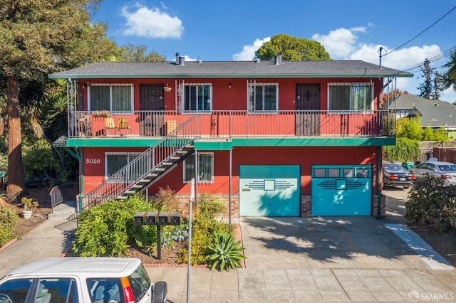 5020 Clarke St, Oakland, CA 94609 - view of front of house with covered porch, a garage, concrete driveway, a shingled roof, and stairs