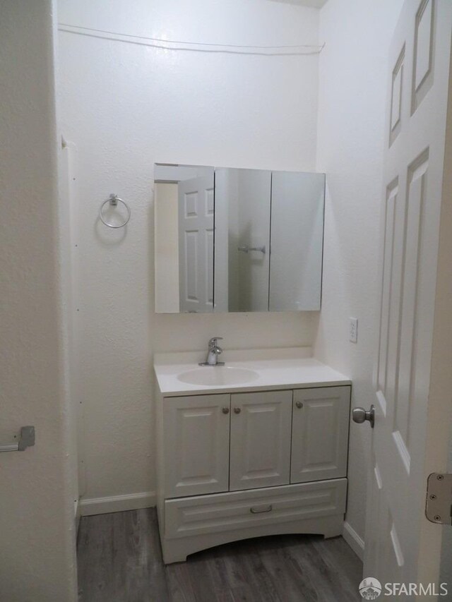 5020 Clarke St, Oakland, CA 94609 - bathroom featuring baseboards, wood finished floors, and vanity