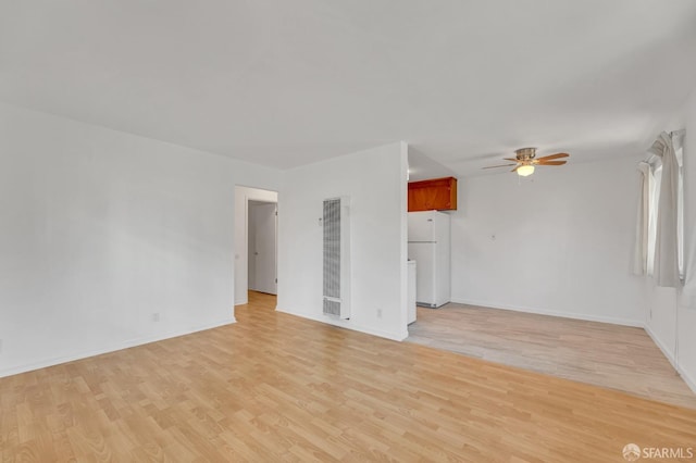 5020 Clarke St, Oakland, CA 94609 - unfurnished living room featuring baseboards, a ceiling fan, light wood-type flooring, and a heating unit