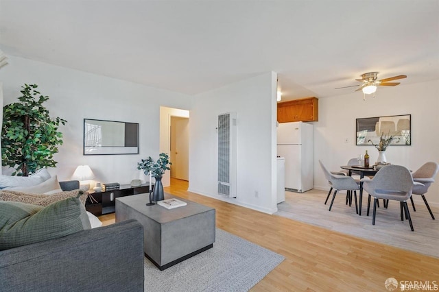 5020 Clarke St, Oakland, CA 94609 - living room featuring a ceiling fan, a heating unit, baseboards, and light wood finished floors