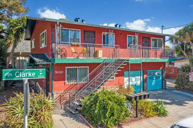 5020 Clarke St, Oakland, CA 94609 - view of front of home featuring stairway, concrete driveway, and stucco siding