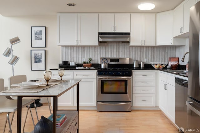 kitchen with stainless steel appliances, tasteful backsplash, and white cabinets