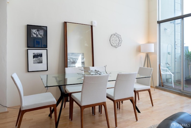 dining area with expansive windows and light wood-type flooring