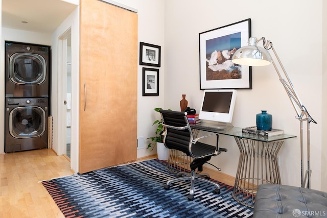 interior space with stacked washing maching and dryer and hardwood / wood-style floors