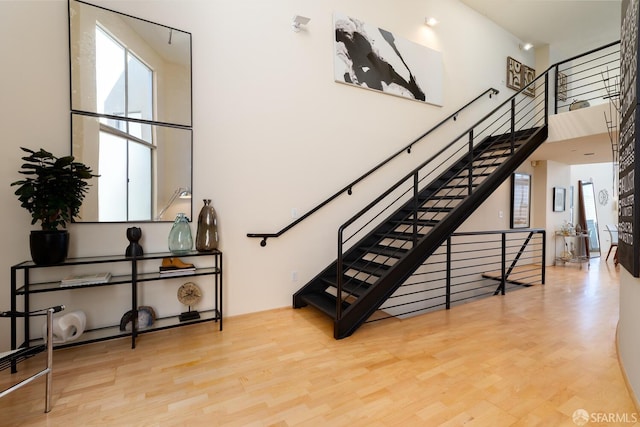 staircase featuring hardwood / wood-style floors and a towering ceiling