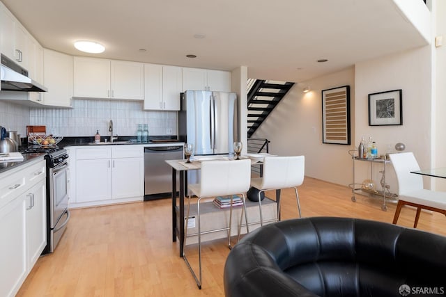 kitchen with tasteful backsplash, stainless steel appliances, sink, and white cabinets