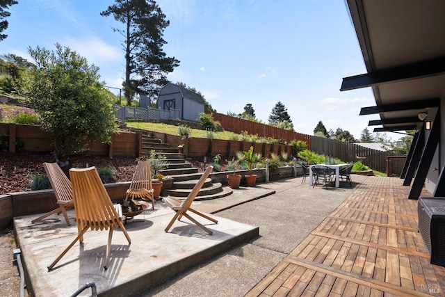 view of patio / terrace with stairs, outdoor dining area, and a fenced backyard