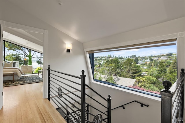 stairway with wood finished floors and lofted ceiling