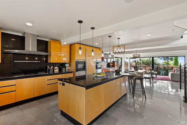 kitchen with decorative backsplash, light brown cabinets, dark countertops, wall chimney range hood, and cooktop