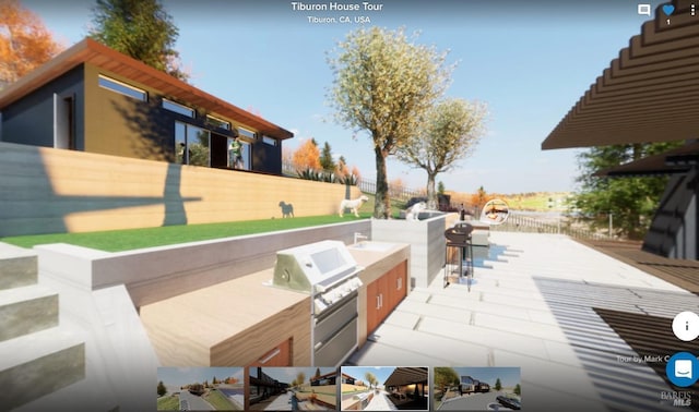 view of patio / terrace featuring fence, area for grilling, and an outdoor kitchen