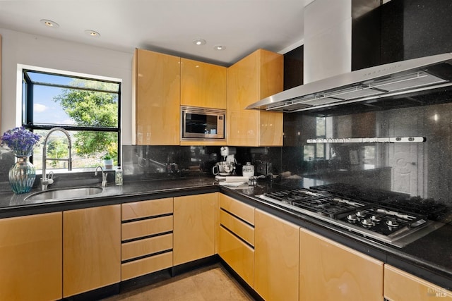 kitchen featuring a sink, decorative backsplash, stainless steel appliances, and wall chimney exhaust hood