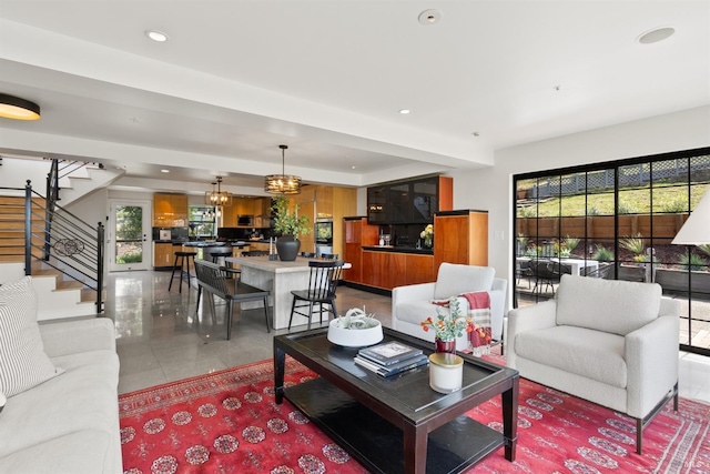 living area featuring recessed lighting, tile patterned flooring, a notable chandelier, and stairway