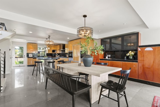 dining space featuring a raised ceiling, recessed lighting, and a chandelier