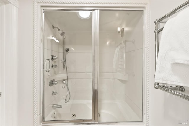 bathroom featuring shower / bath combination with glass door