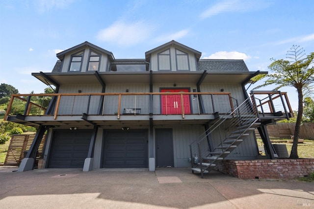 view of front of house featuring fence, roof with shingles, an attached garage, driveway, and stairway
