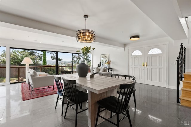 dining space with baseboards, stairs, and a notable chandelier