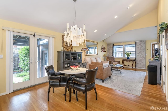 dining area featuring light hardwood / wood-style floors, high vaulted ceiling, and a chandelier