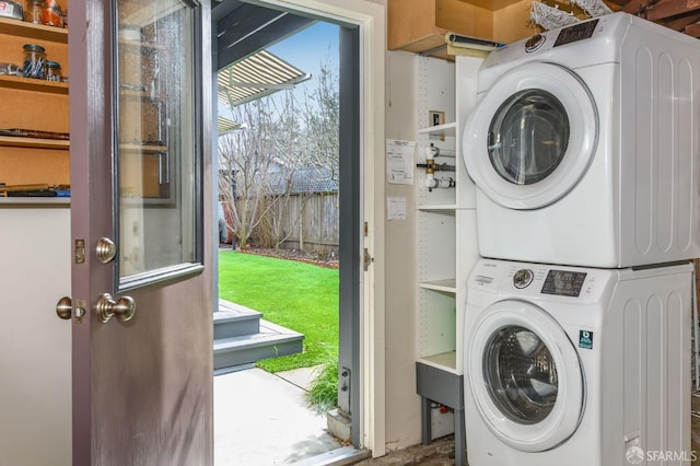 clothes washing area featuring stacked washing maching and dryer