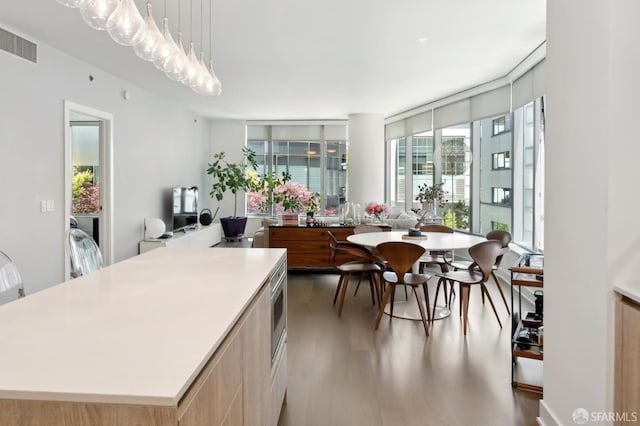 333 Beale St Unit 4E, San Francisco, CA 94105 - kitchen featuring wood finished floors, a center island, open floor plan, light countertops, and decorative light fixtures