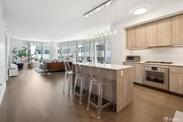 333 Beale St Unit 4E, San Francisco, CA 94105 - kitchen with stainless steel oven, light brown cabinetry, modern cabinets, light wood finished floors, and a kitchen breakfast bar