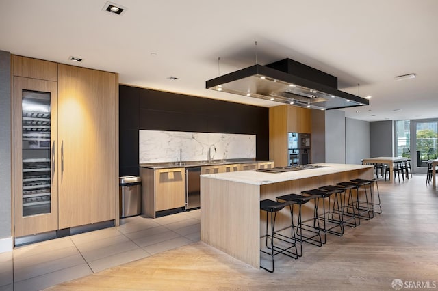 333 Beale St Unit 4E, San Francisco, CA 94105 - kitchen with modern cabinets, backsplash, a large island, a breakfast bar, and light countertops