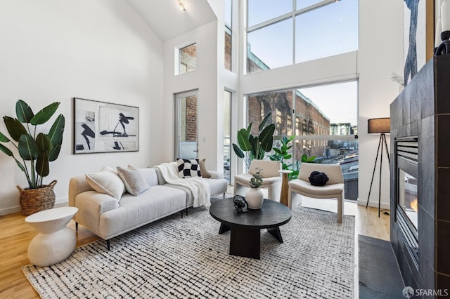 living room featuring a towering ceiling and wood-type flooring