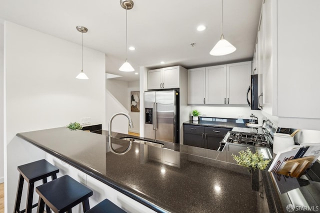 kitchen featuring hanging light fixtures, kitchen peninsula, sink, and high end fridge