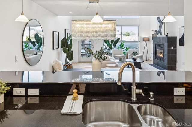 kitchen featuring hanging light fixtures, sink, and a tile fireplace