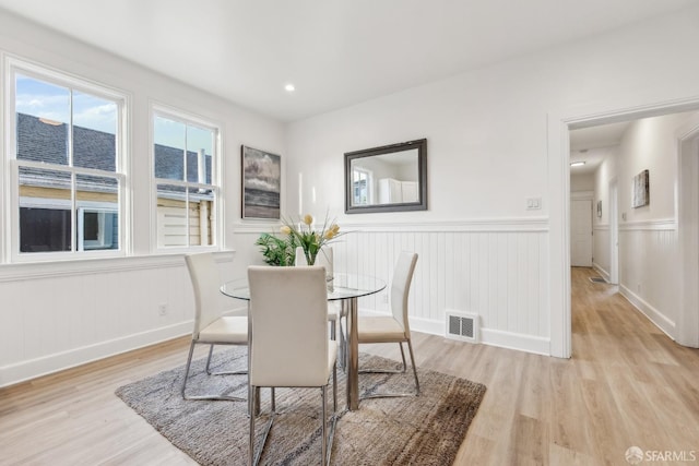 1015 Key Ave, San Francisco, CA 94124 - dining space with light wood-style flooring, a wainscoted wall, and a decorative wall
