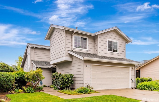 view of front facade with driveway, a front yard, and a garage