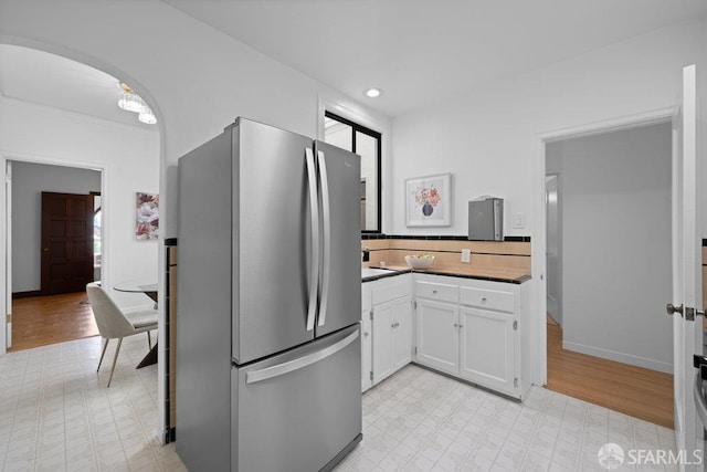 57 Masonic Ave, San Francisco, CA 94118 - kitchen featuring freestanding refrigerator, light flooring, white cabinetry, and arched walkways
