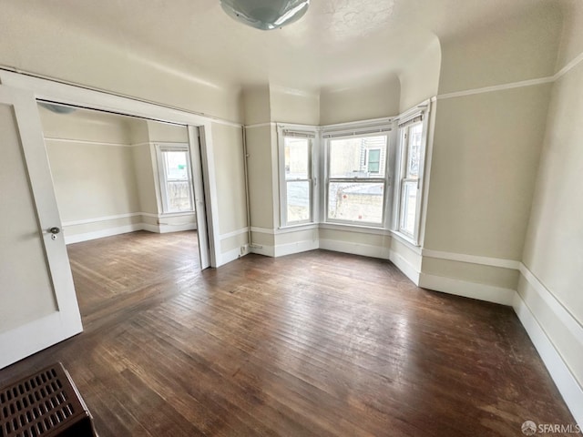 unfurnished bedroom featuring wood finished floors, visible vents, and baseboards