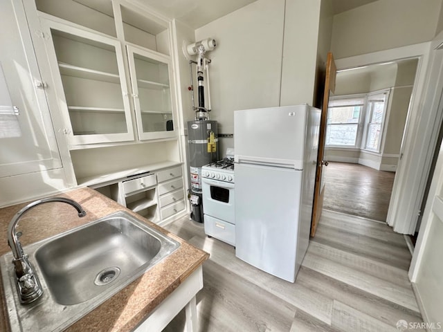 kitchen featuring gas water heater, white appliances, a sink, light wood finished floors, and glass insert cabinets