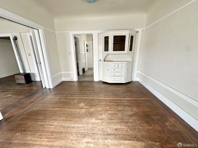 empty room with dark wood-style floors and baseboards