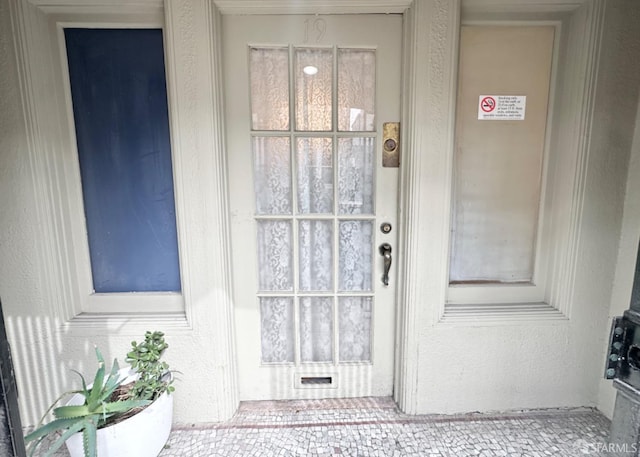 doorway to property featuring stucco siding