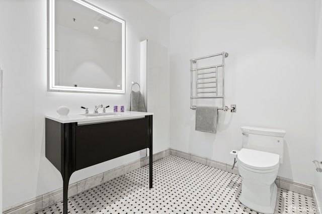bathroom featuring baseboards, vanity, and toilet