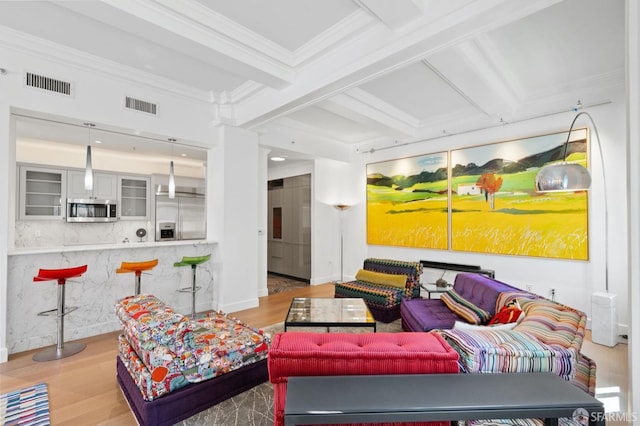 living area featuring ornamental molding, visible vents, and wood finished floors