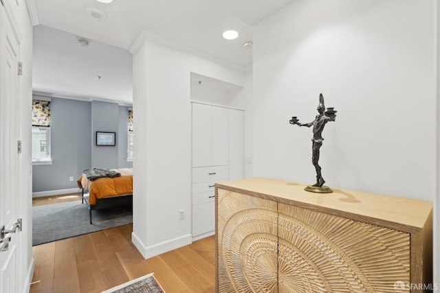 hallway featuring baseboards, light wood-type flooring, and recessed lighting