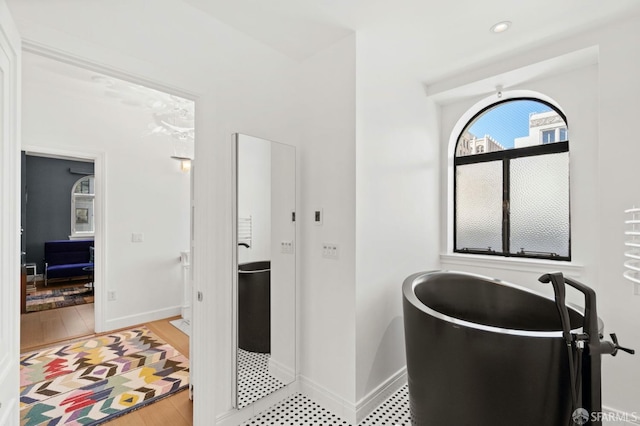 full bath with baseboards and a soaking tub