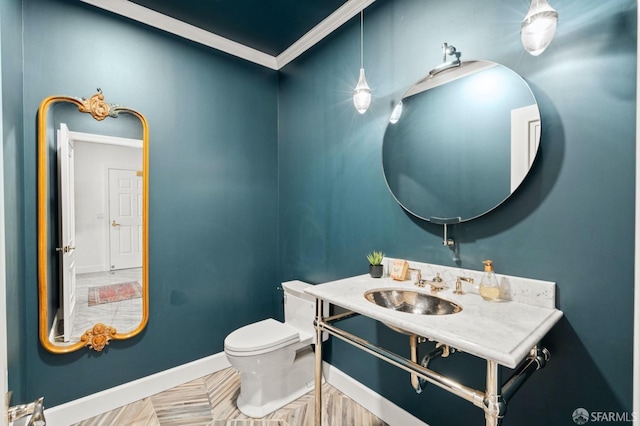 bathroom with a sink, toilet, and baseboards