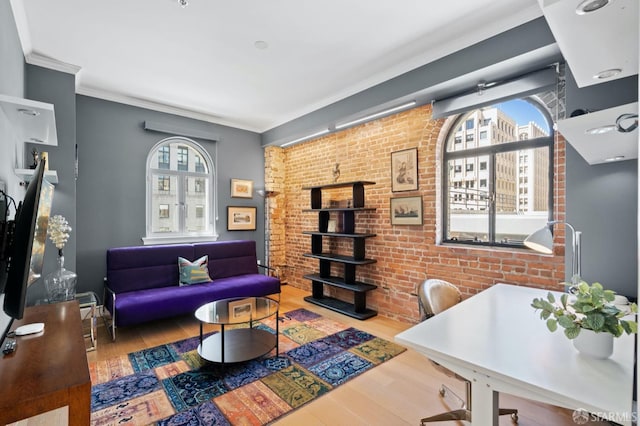 office space with ornamental molding, brick wall, and wood finished floors