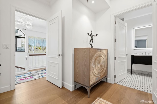 living area with baseboards, a chandelier, and wood finished floors